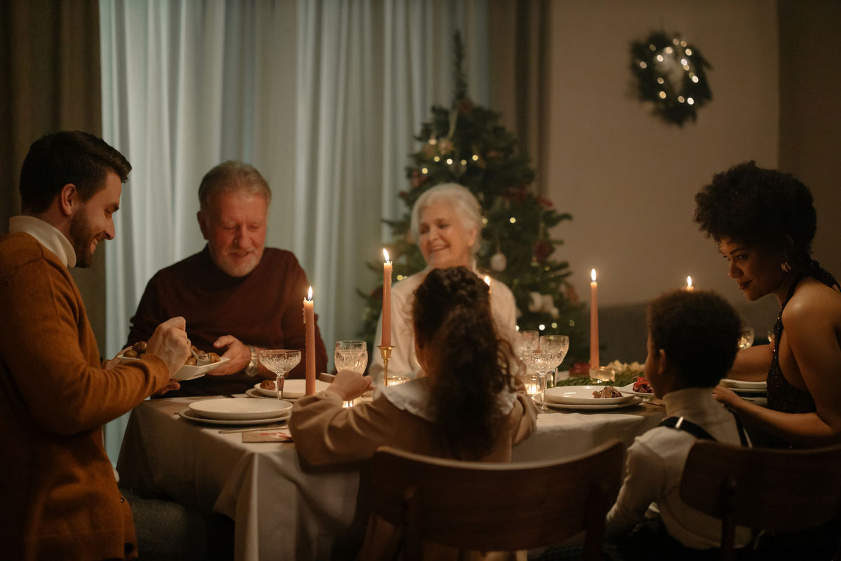 Tre generationer vid ett dukat bord bredvid granen