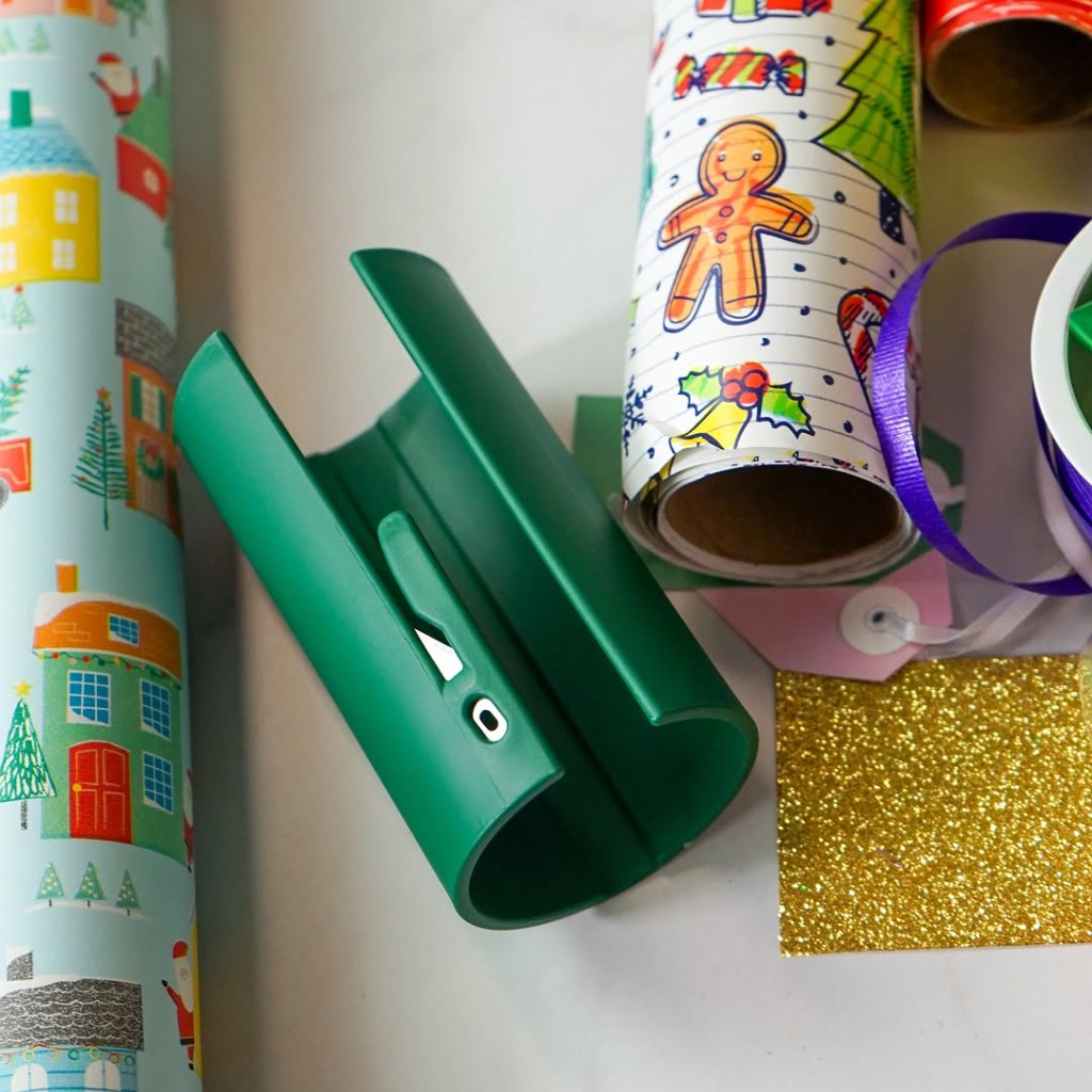 Grönt Julsnitt bredvid rullar med presentpapper