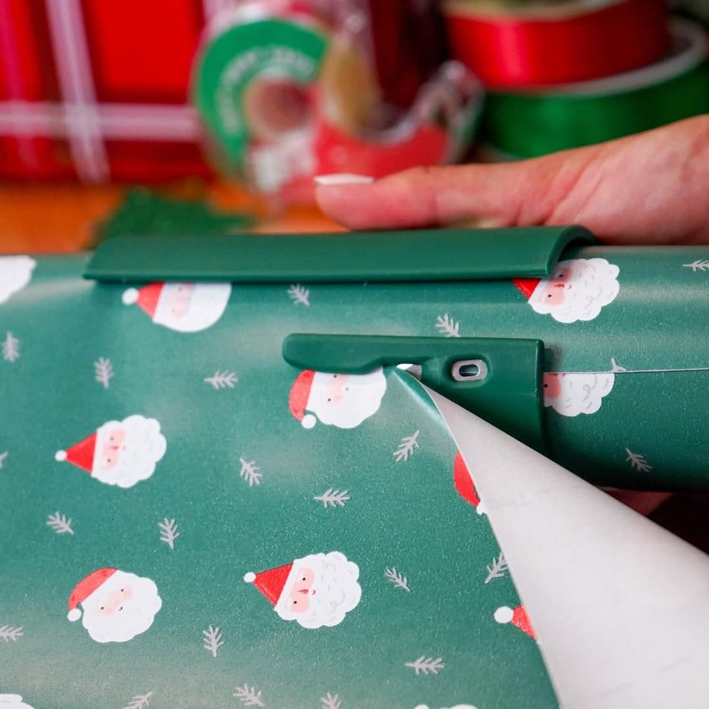 Julsnittet skär rakt i grönt julpapper med tomtar