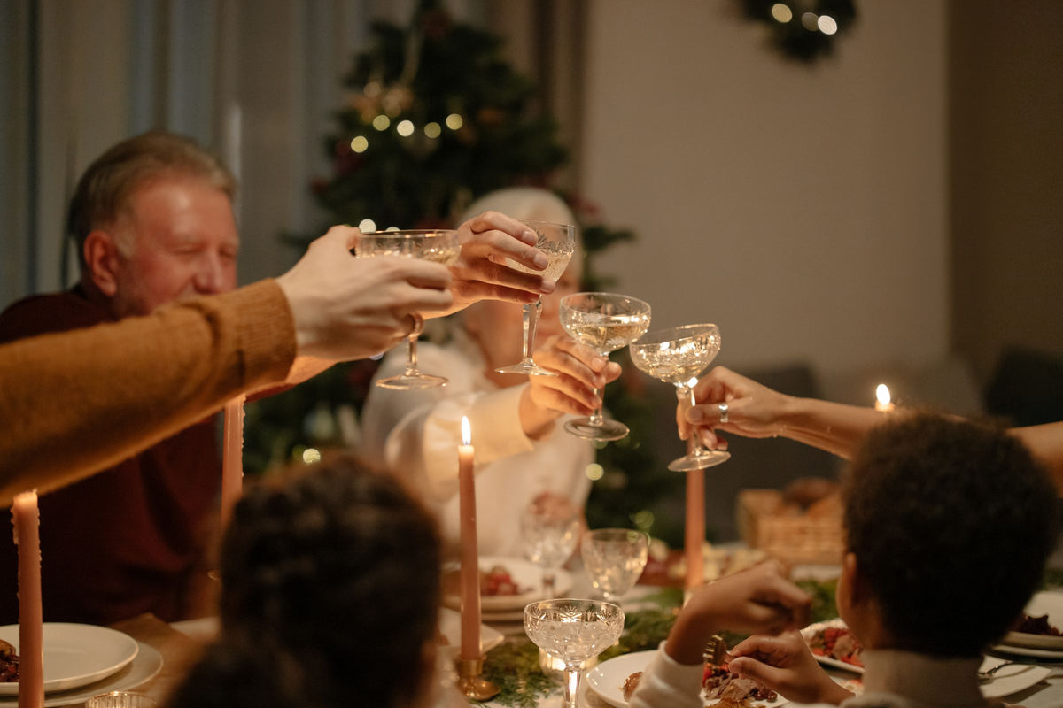 Familj som skålar vid ett dukat bord i levande ljus